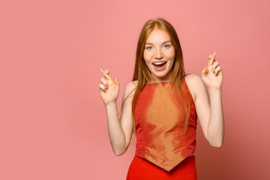 Portrait of happy young woman on pink background, space for text