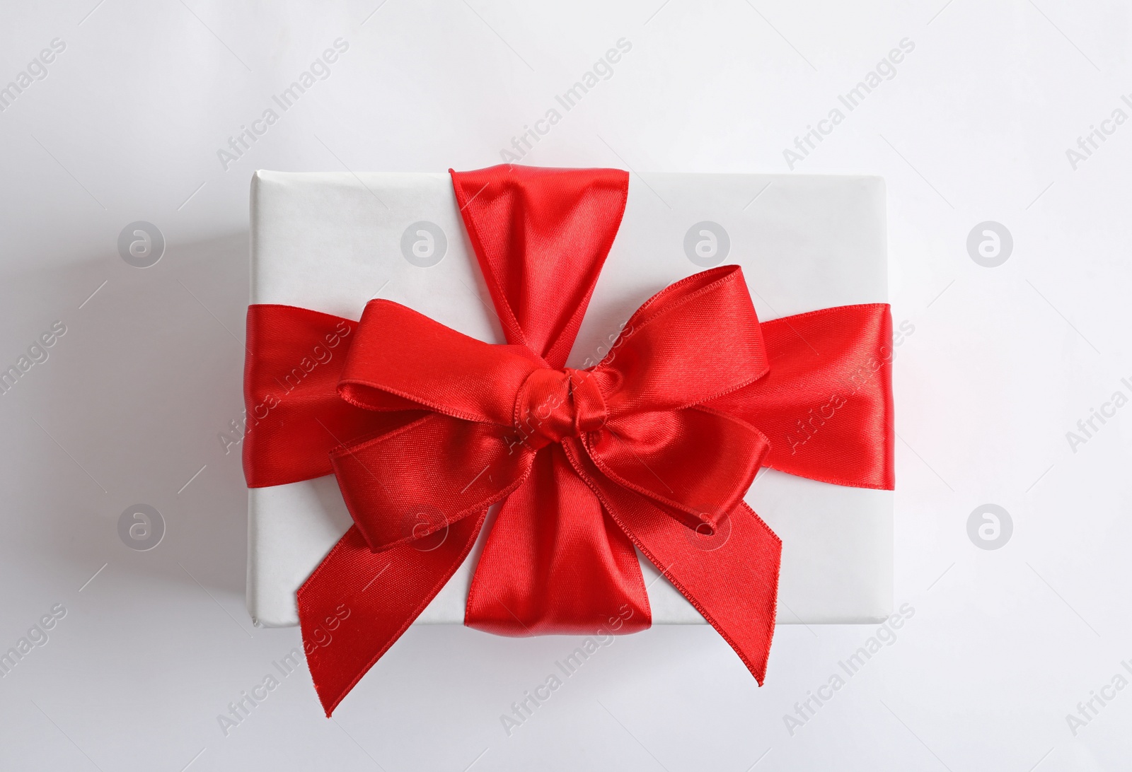 Photo of Beautifully wrapped gift box on white background, top view