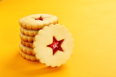 Photo of Traditional Christmas Linzer cookies with sweet jam on color background