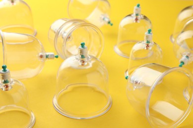 Photo of Plastic cups on yellow background. Cupping therapy