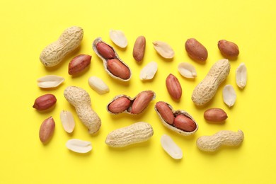 Fresh peanuts on yellow background, flat lay