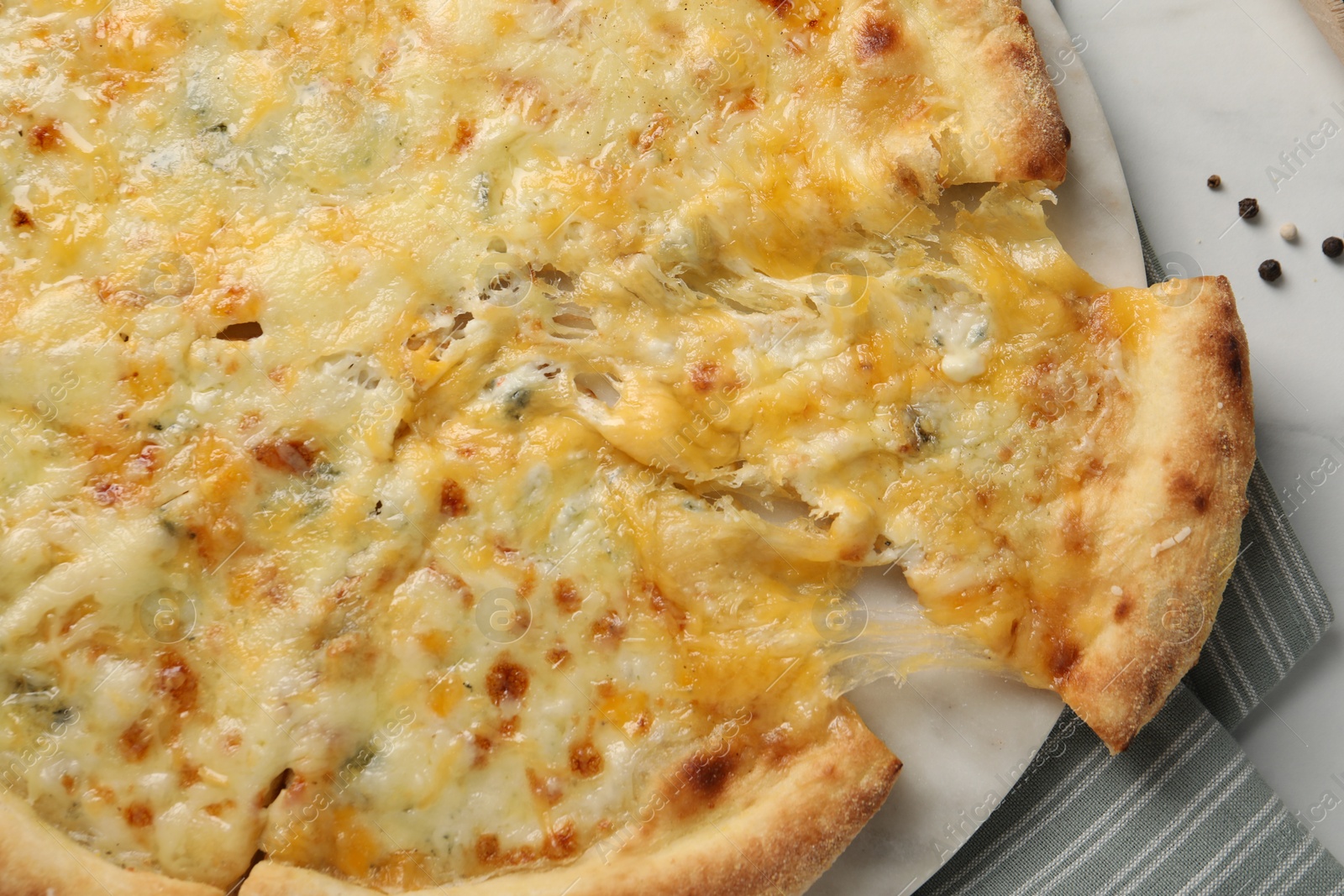 Photo of Delicious cut cheese pizza on white table, top view