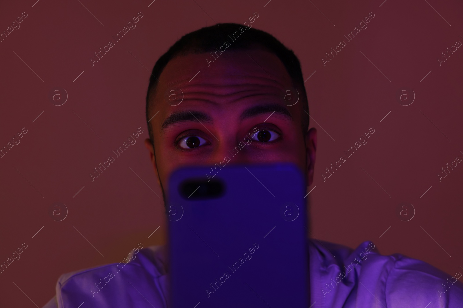 Photo of Man using smartphone at night, closeup. Internet addiction