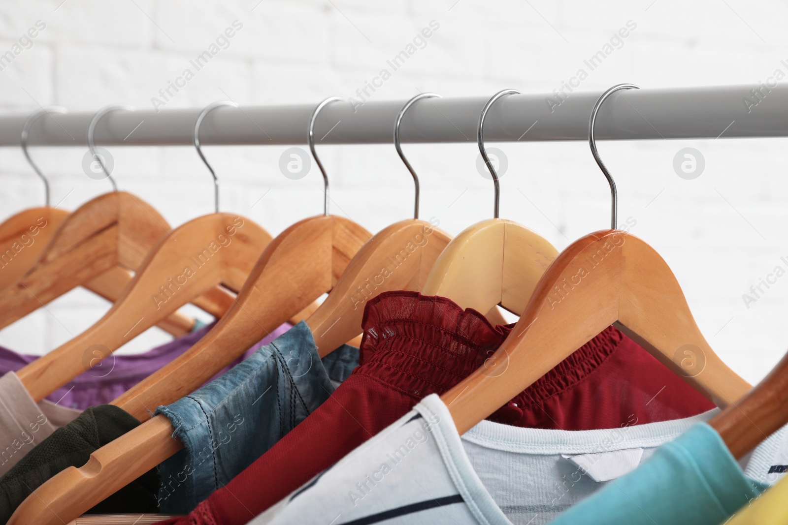 Photo of Wardrobe rack with stylish clothes on white background, closeup