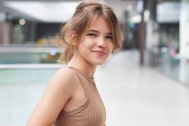 Photo of Portrait of beautiful teenage girl in shopping mall. Space for text