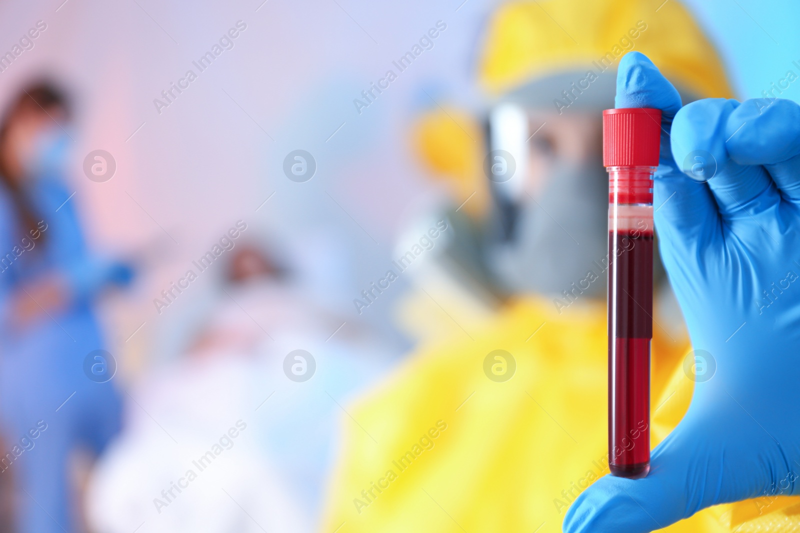 Photo of Closeup view of paramedic holding test tube with sample of virus in quarantine ward, space for text