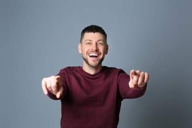 Photo of Handsome man laughing on grey background. Funny joke