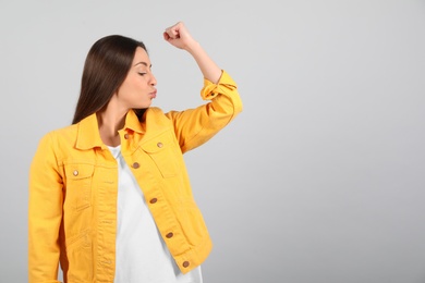 Photo of Strong woman as symbol of girl power on light grey background, space for text. 8 March concept