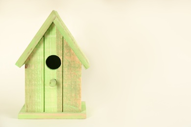 Beautiful bird house on beige background, space for text