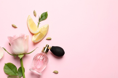 Photo of Flat lay composition with elegant perfume on pink background, space for text