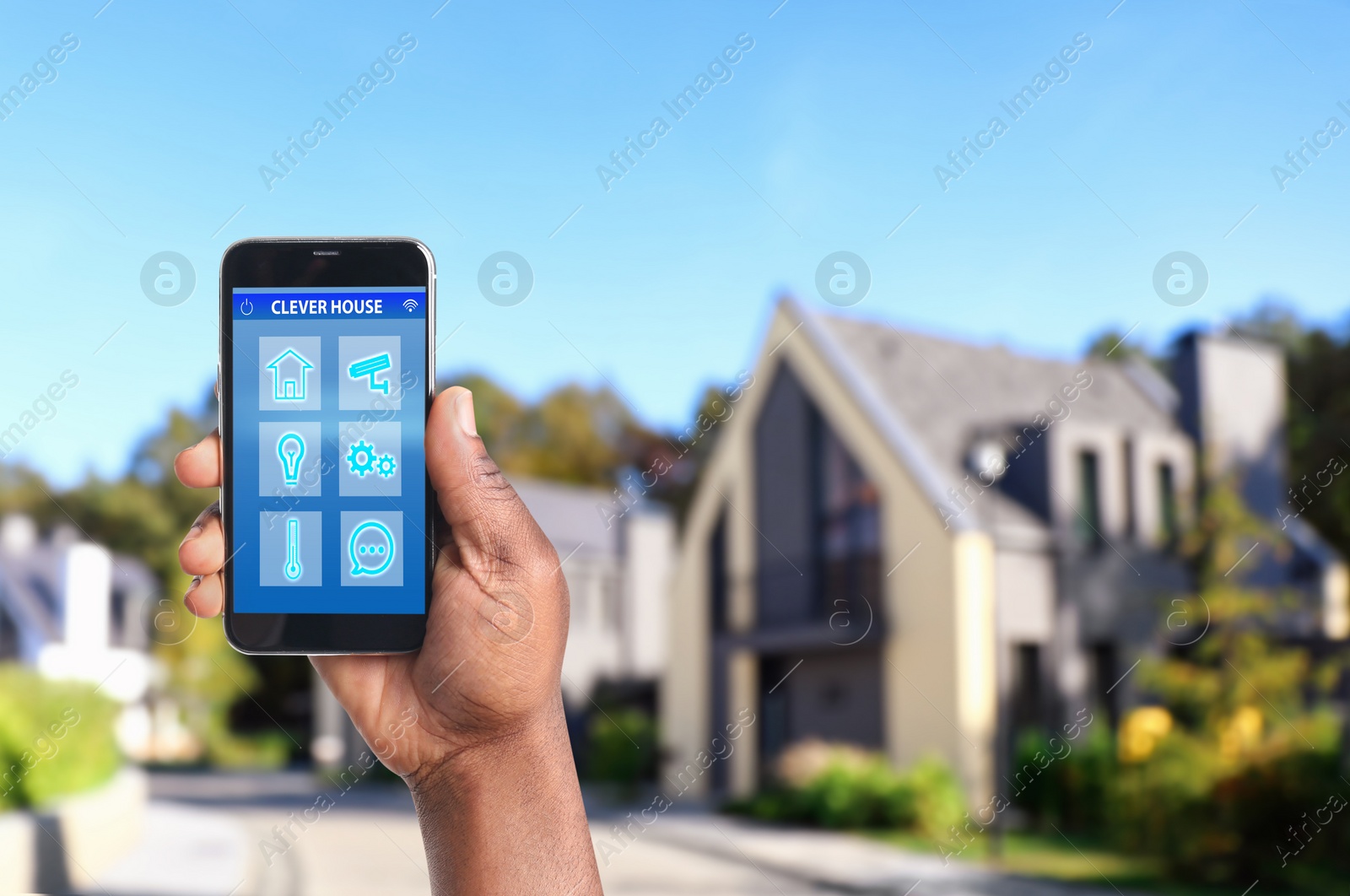 Image of African-American man using home security app on smartphone outdoors, closeup. Space for text