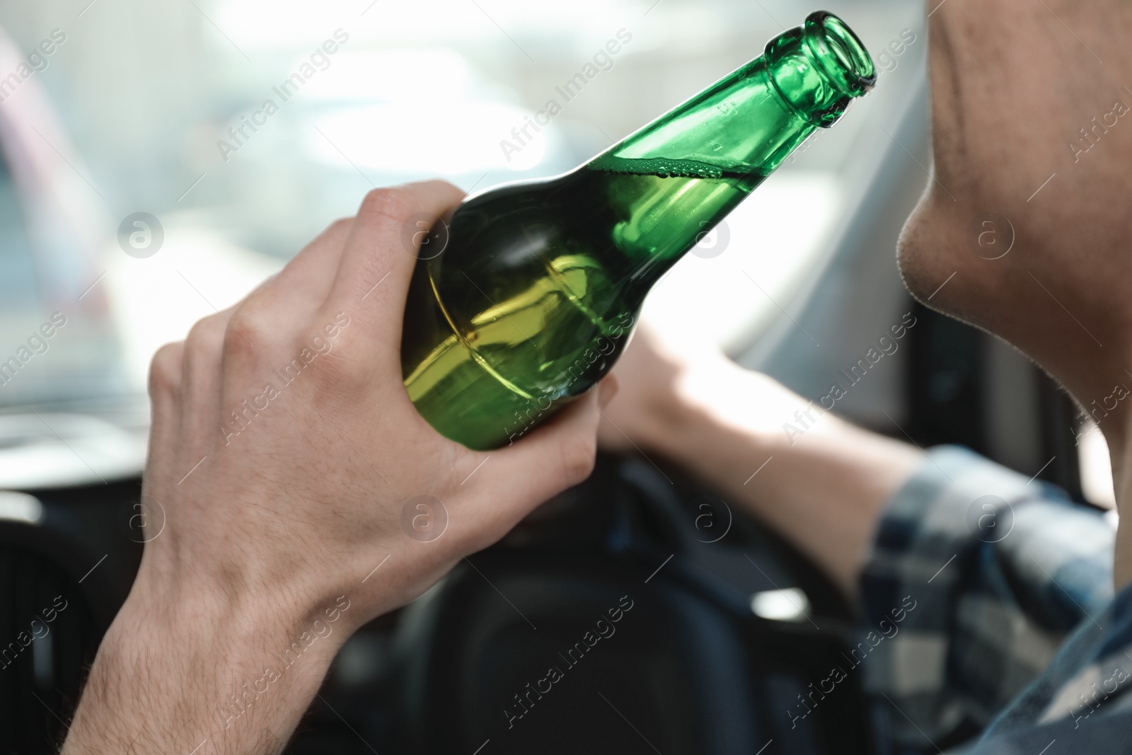 Photo of Man with bottle of beer driving car, closeup. Don't drink and drive concept