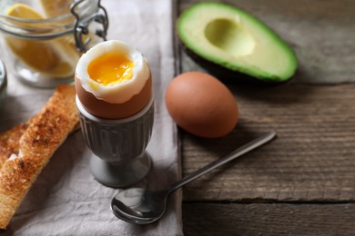 Photo of Soft boiled egg served for breakfast on wooden table