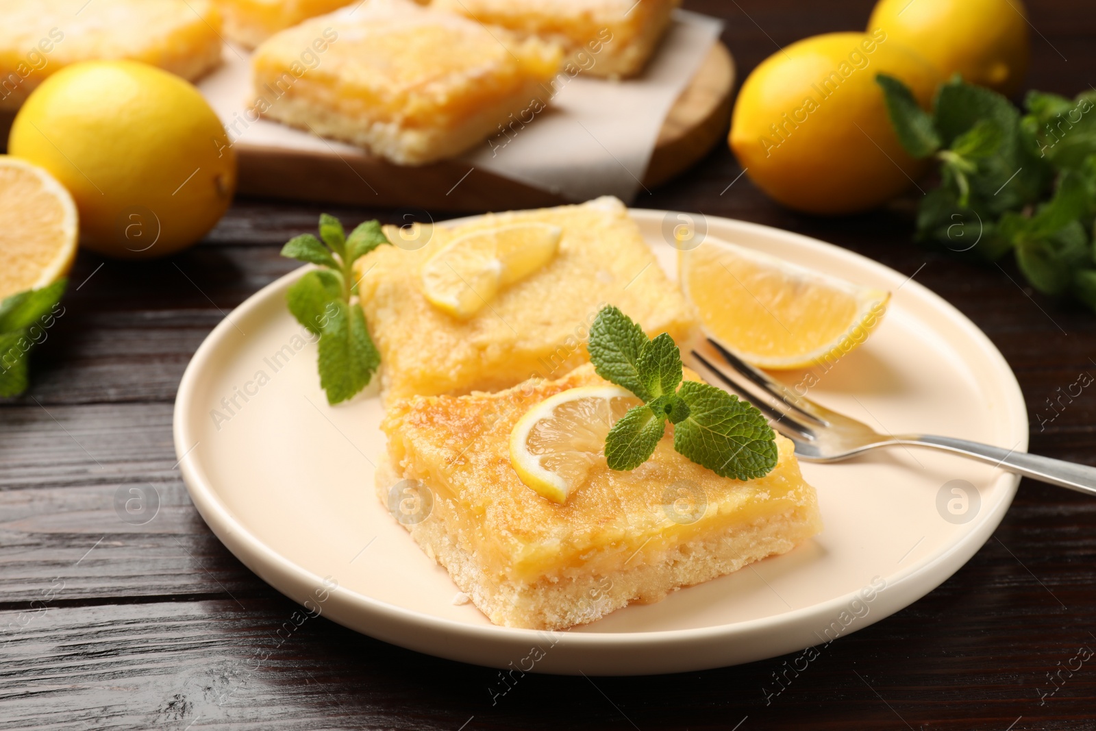 Photo of Tasty lemon bars served on wooden table, closeup