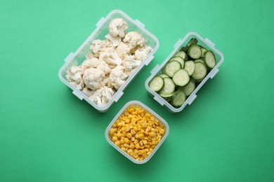 Photo of Plastic containers with different fresh products on green background, flat lay