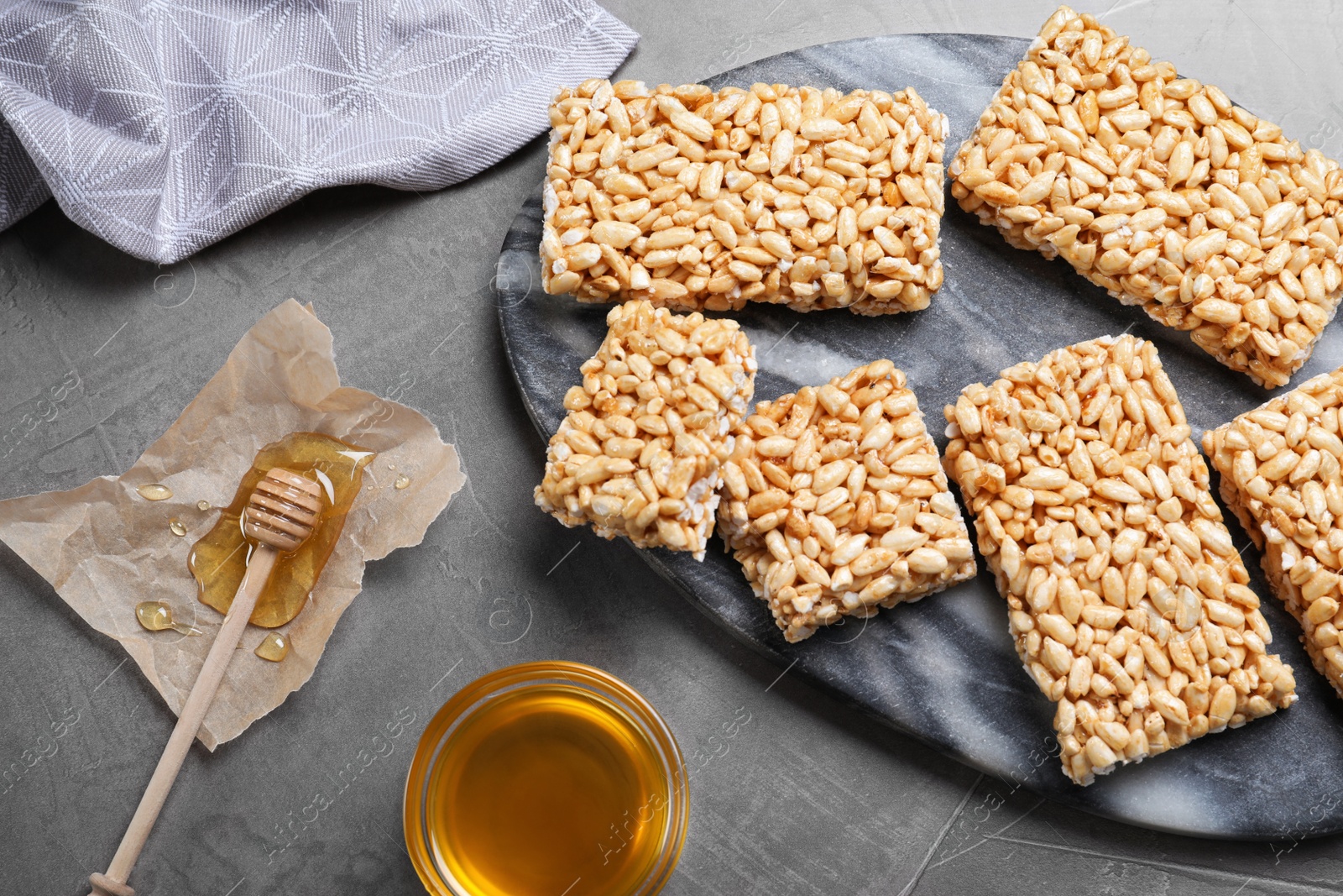 Photo of Delicious rice crispy treats on grey table, flat lay