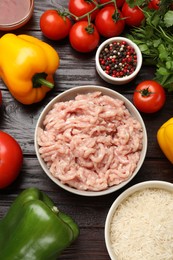 Photo of Making stuffed peppers. Ground meat and other ingredients on wooden table, flat lay