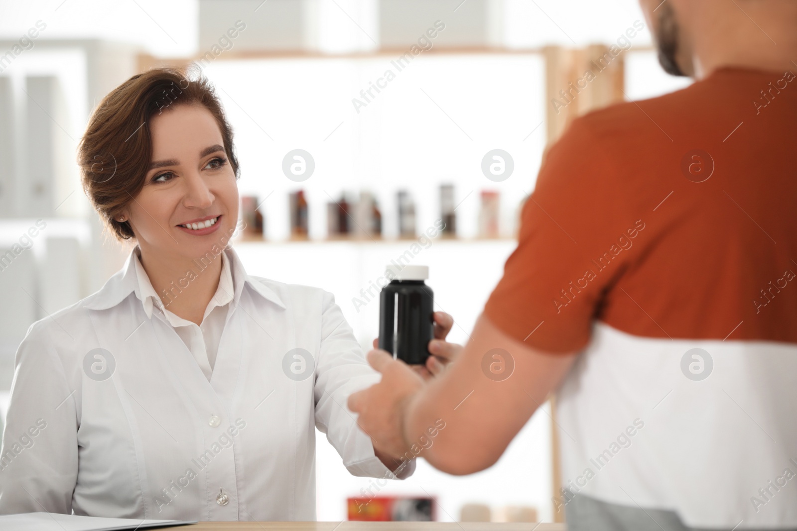 Photo of Pharmacist giving medicine to customer in drugstore