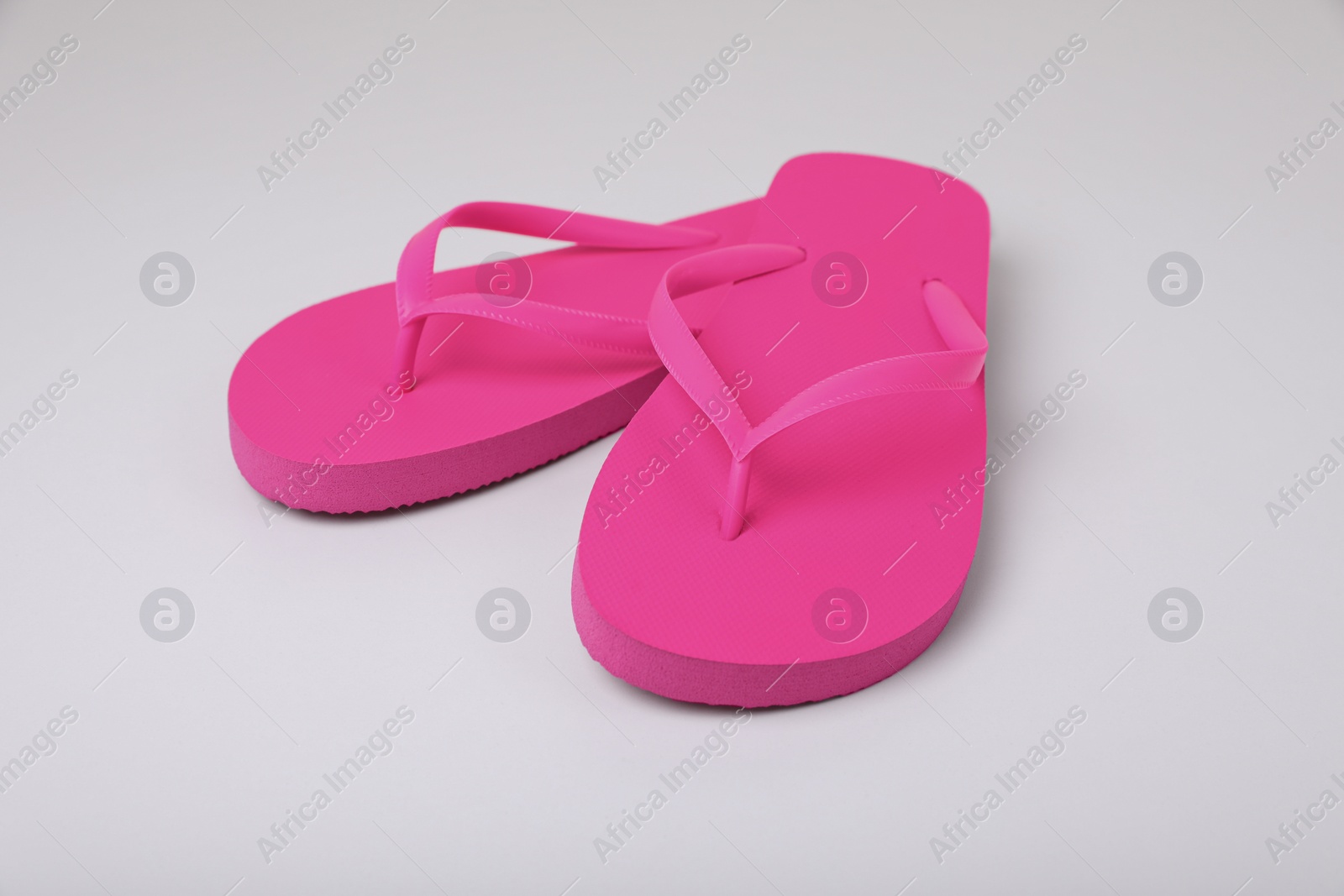 Photo of Stylish pink flip flops on white background