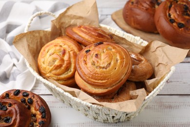 Photo of Different delicious rolls on white wooden table. Sweet buns