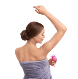 Young woman applying deodorant to armpit on white background