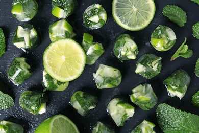 Photo of Lime and mint ice cubes on dark background, flat lay