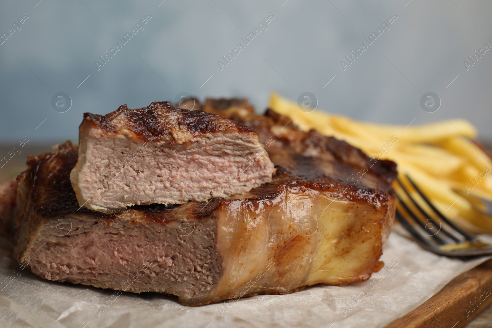 Photo of Tasty grilled beef steak on wooden table, closeup