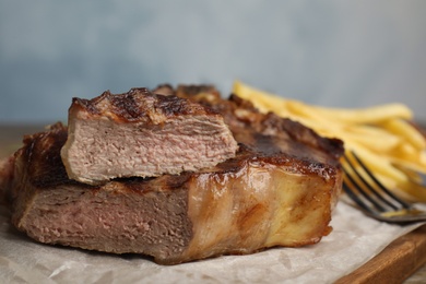 Tasty grilled beef steak on wooden table, closeup