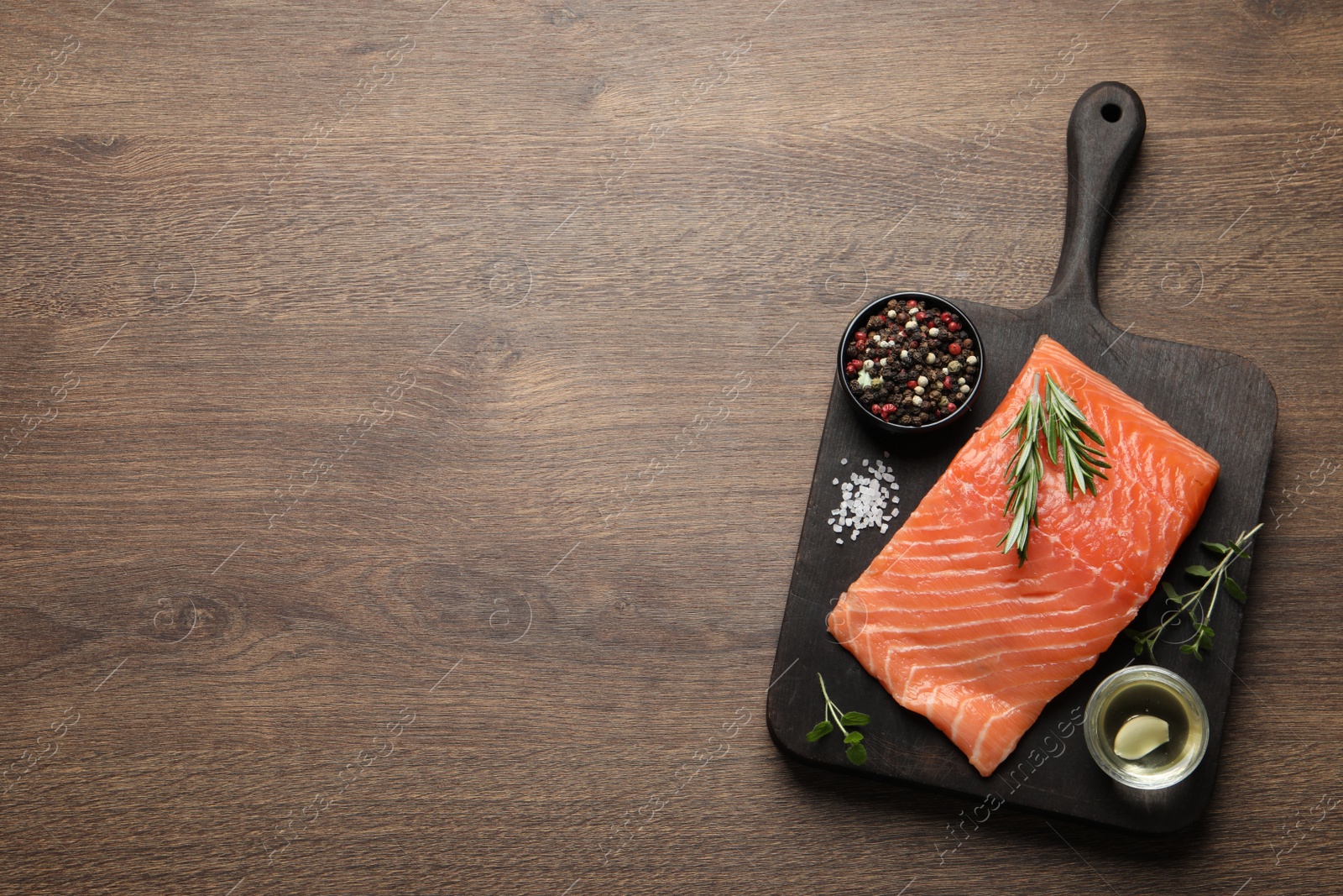 Photo of Fresh raw salmon and ingredients on wooden table, top view. Space for text