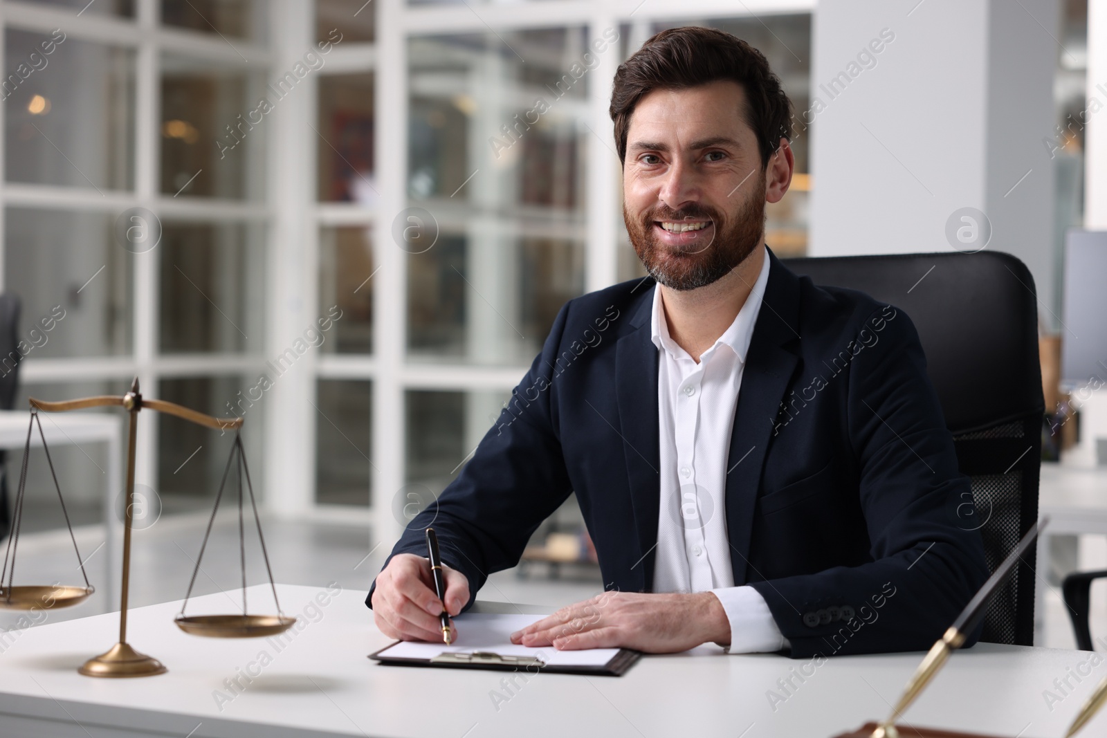 Photo of Portrait of smiling lawyer at table in office