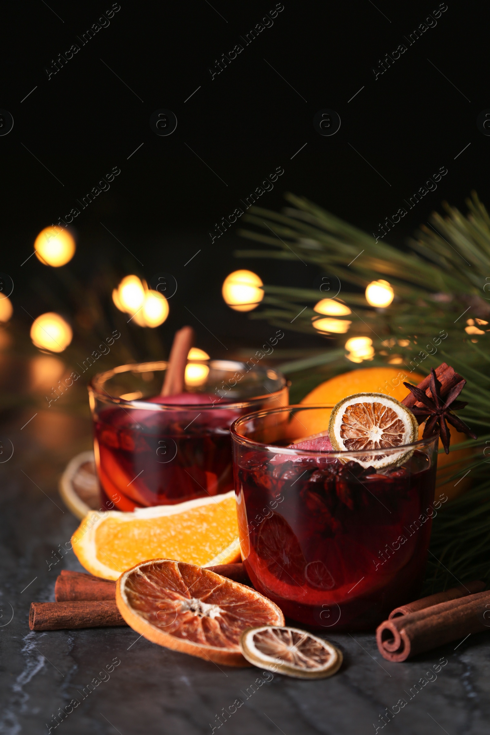 Photo of Glasses with mulled wine on table against blurred background