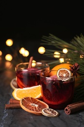 Glasses with mulled wine on table against blurred background