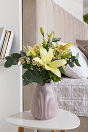 Photo of Bouquet of beautiful flowers on white table in bedroom