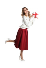 Beautiful young woman with Christmas present on white background