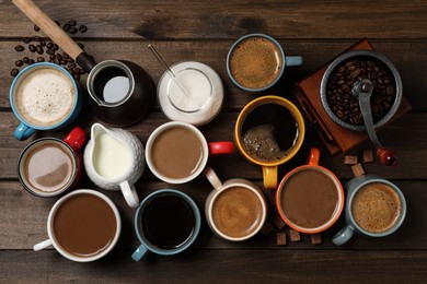 Photo of Cups of fresh aromatic coffee on wooden table, flat lay