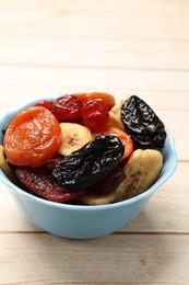 Photo of Mix of delicious dried fruits on white wooden table, closeup