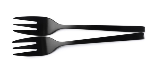 Photo of New black dessert forks on white background, top view