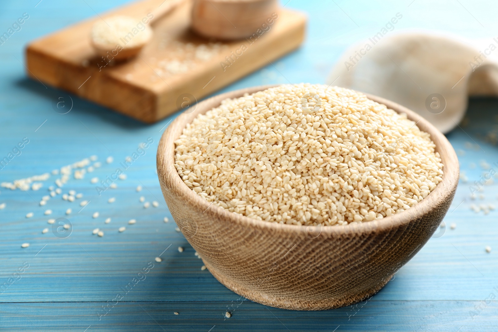 Photo of White sesame seeds on light blue wooden table