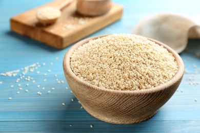 Photo of White sesame seeds on light blue wooden table