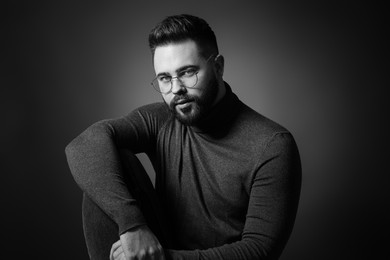 Portrait of handsome bearded man on dark background. Black and white effect