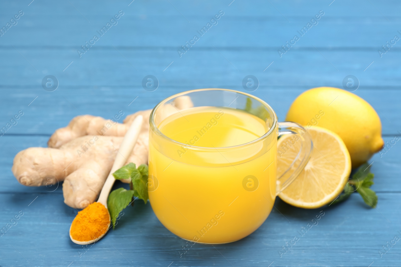 Photo of Immunity boosting drink and ingredients on blue wooden table