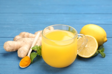 Photo of Immunity boosting drink and ingredients on blue wooden table