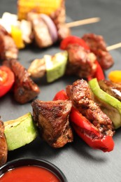 Photo of Delicious shish kebabs with vegetables on grey table, closeup