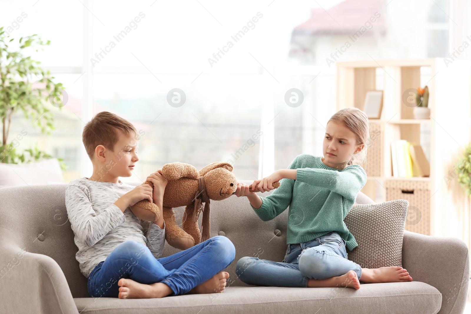 Photo of Brother arguing with sister on sofa at home