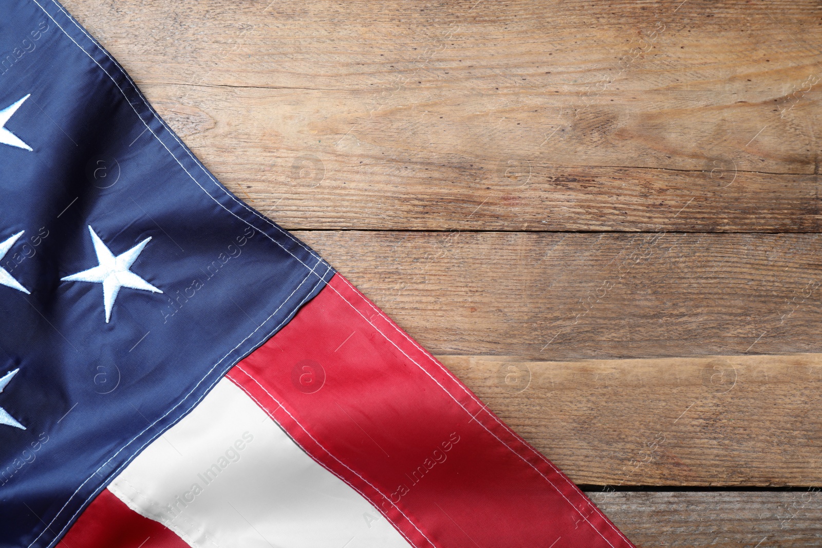 Photo of National flag of America on wooden table, top view. Space for text