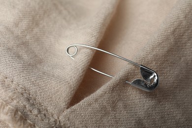 Photo of Closeup view of metal safety pin on clothing