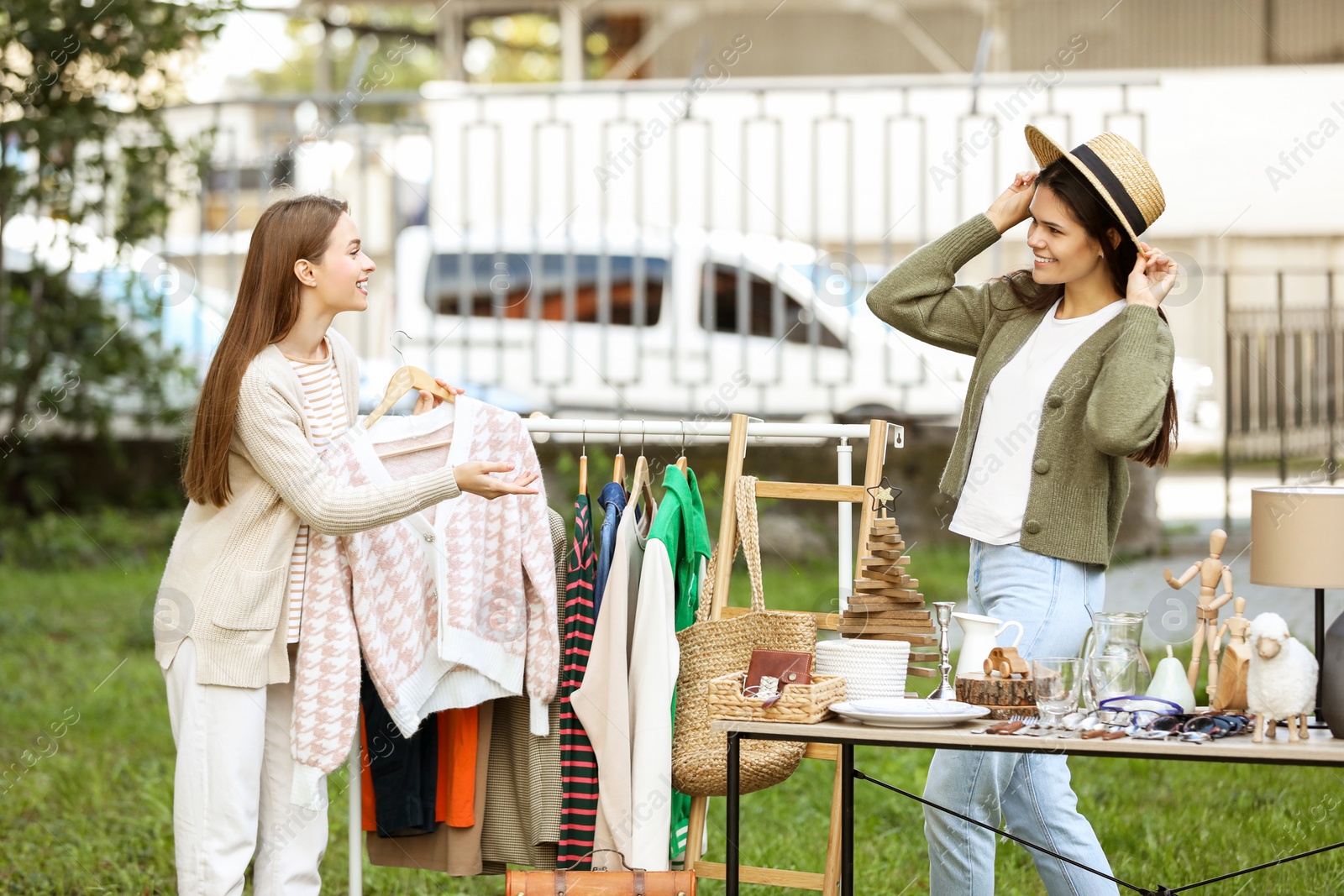 Photo of Young women shopping in yard. Garage sale