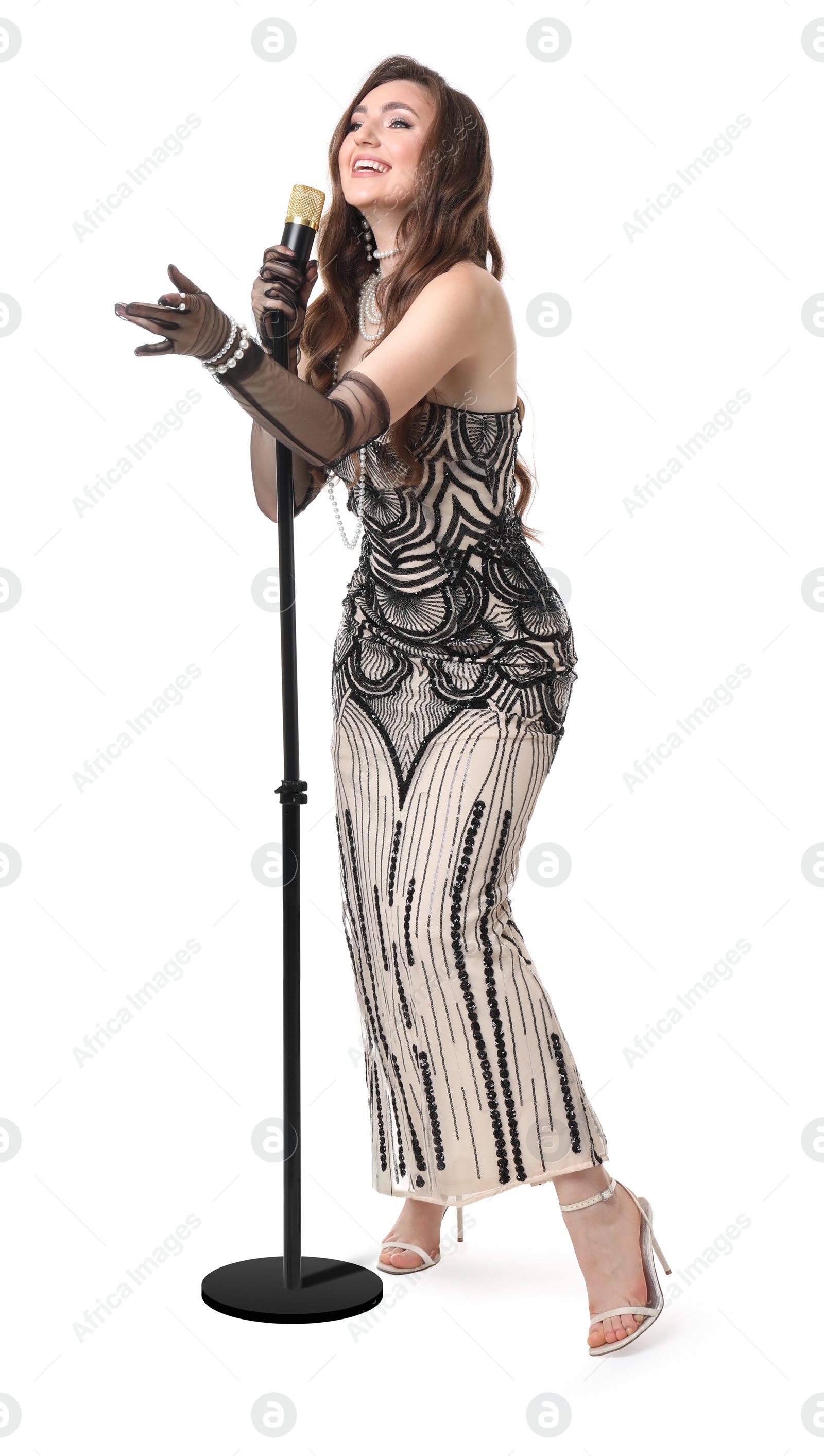 Photo of Beautiful young woman in stylish dress with microphone singing on white background