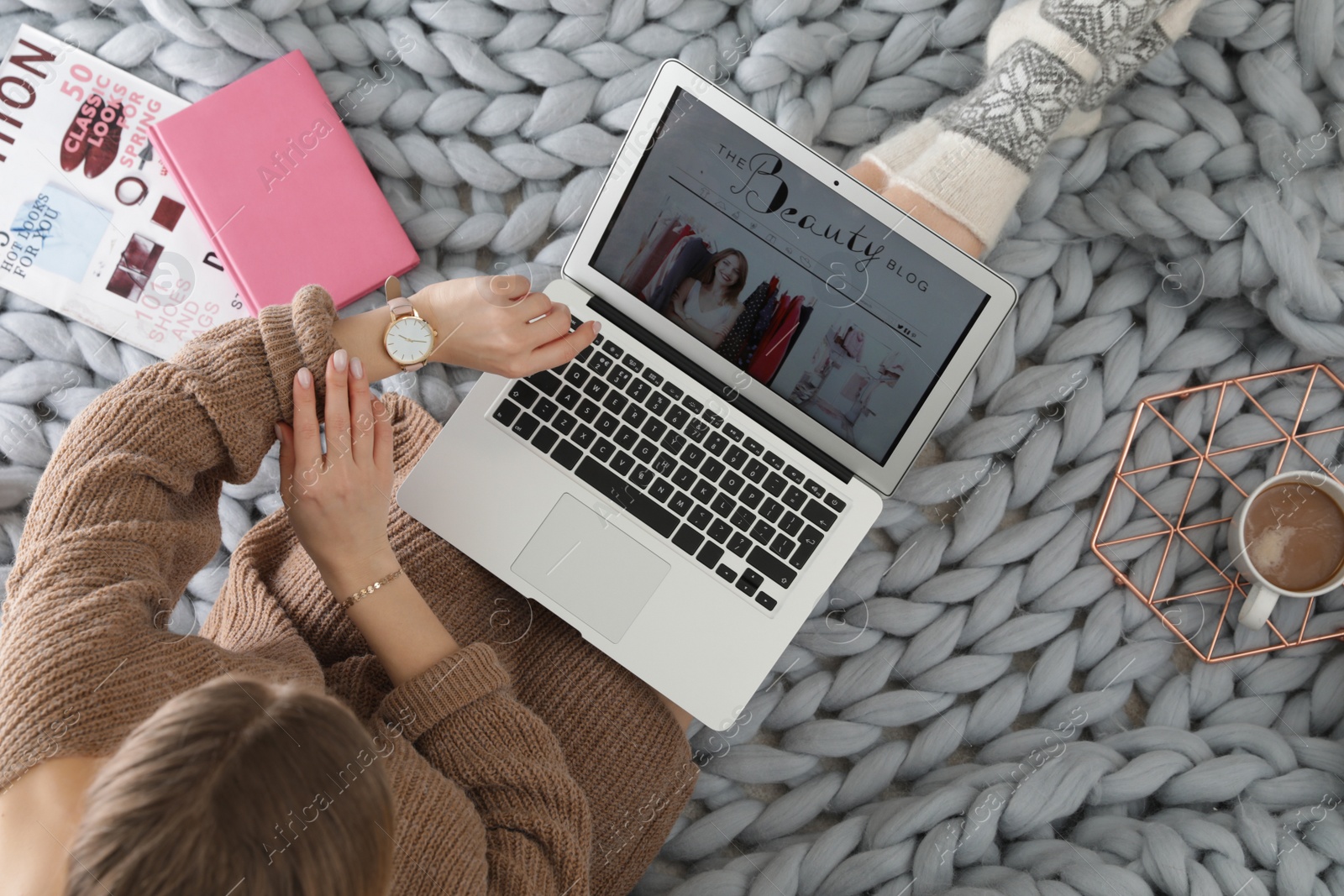 Photo of Woman and laptop with beauty blogger site on plaid, top view