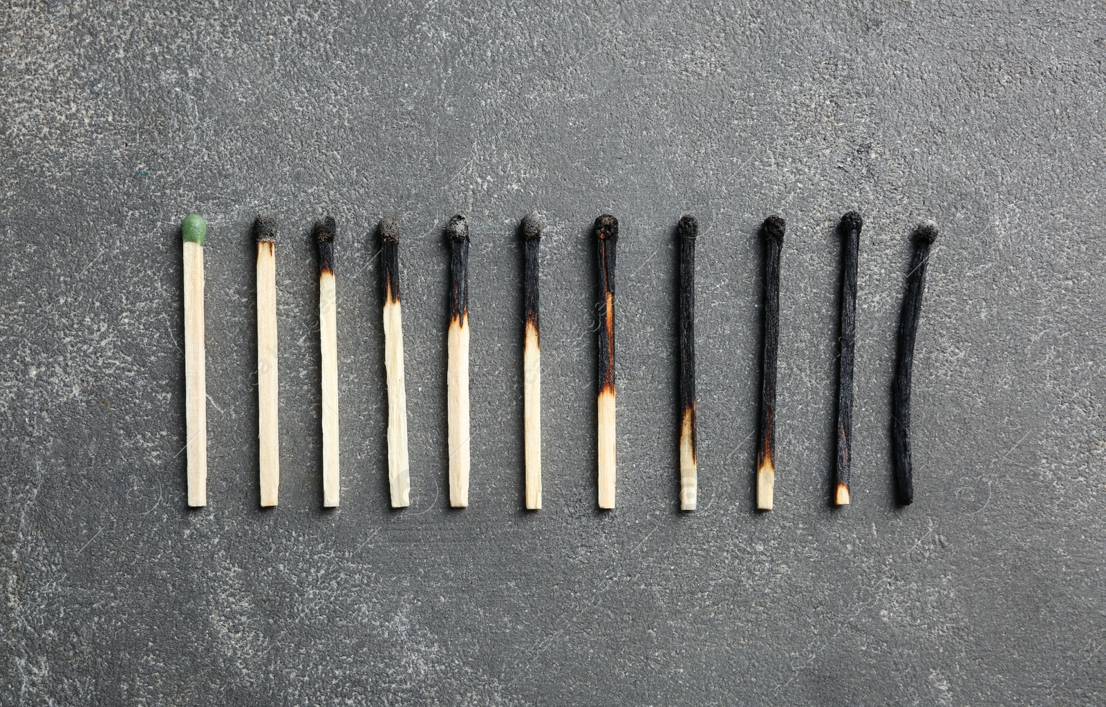 Photo of Row of burnt matches and whole one on grey background, flat lay. Human life phases concept